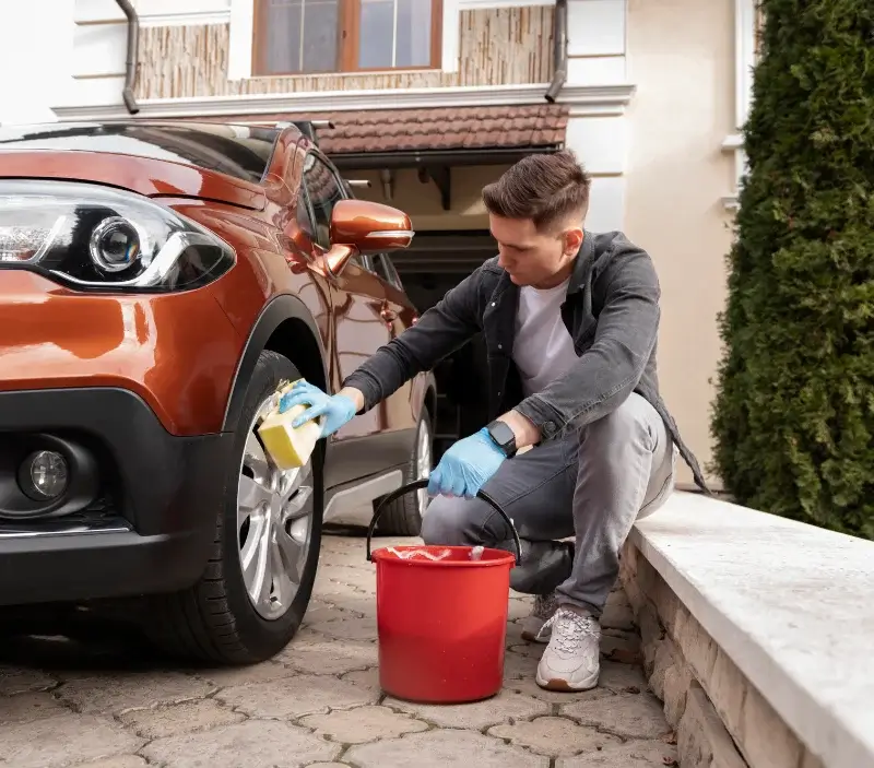 Lavage auto à domicile Tourville-la-Campagne : professionnel intervenant sur un véhicule